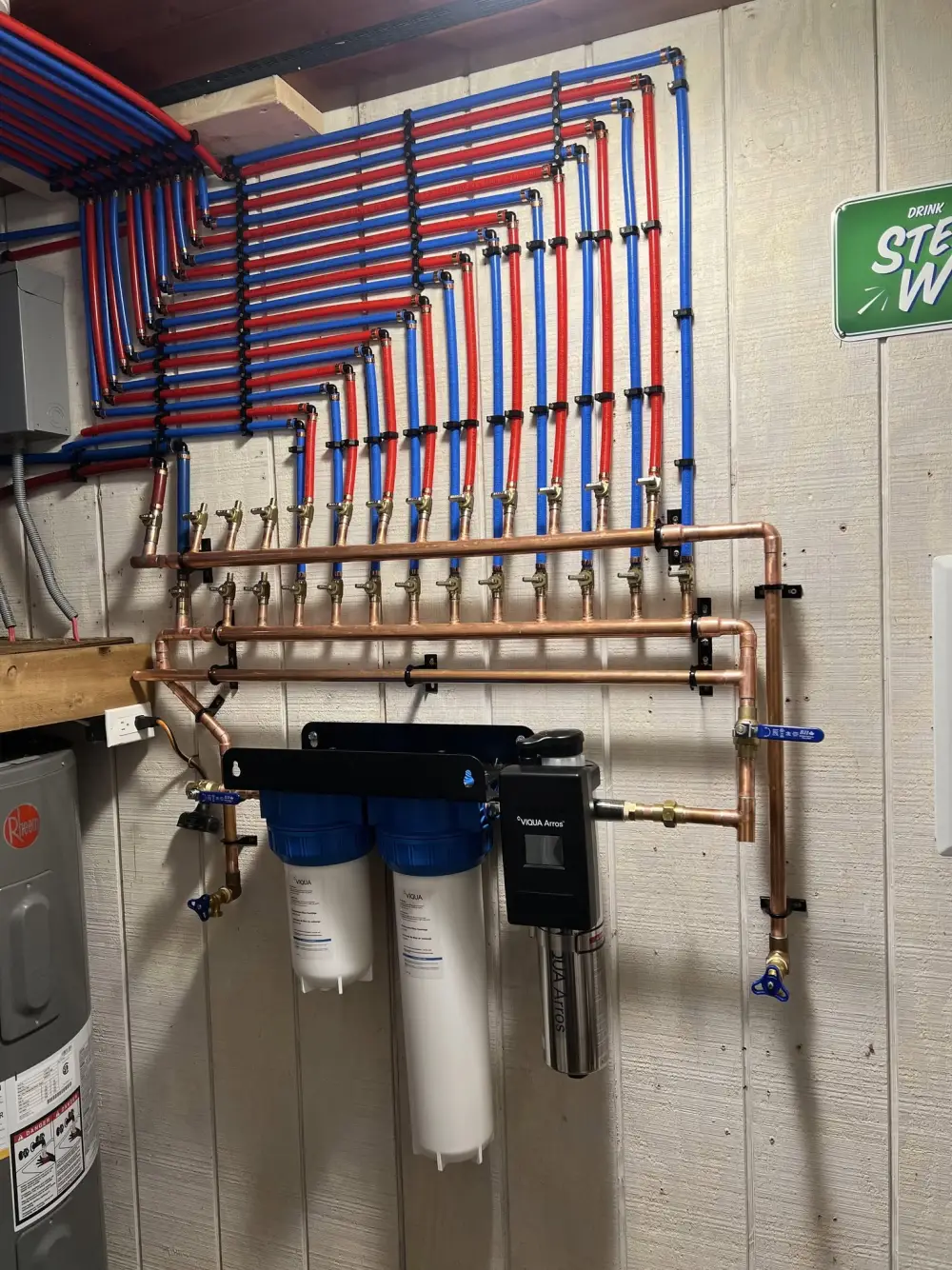 PEX and copper plumbing manifold with filtration installed by Crofty's Plumbing in a Muskoka cottage